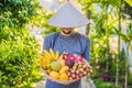 Variety of fruits in a Vietnamese hat. Man in a Vietnamese hat Royalty Free Stock Photo