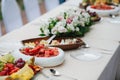 Variety of fuits and meats served on a big narrow dining table Royalty Free Stock Photo