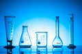 Variety of glass flasks and lab equipment on a blue background Royalty Free Stock Photo