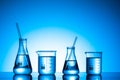 Variety of glass flasks and lab equipment on a blue background Royalty Free Stock Photo