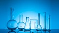 Variety of glass flasks and lab equipment on a blue background Royalty Free Stock Photo