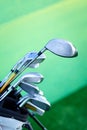 Variety of golf clubs in bag on green background