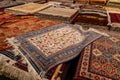 Variety of gorgeous oriental carpets in traditional carpet store in Middle East. Pile of beautiful handmade carpets on Royalty Free Stock Photo