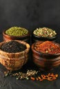 Variety of gourmet spices and seasonings displayed in wooden bowls on dark background