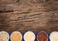 Variety of grain rice in cup on natural wooden background