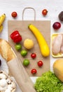 Variety of healthy food with paper bag on white wooden table, overhead. Cooking food background. Fresh fruits, vegetables, greens, Royalty Free Stock Photo