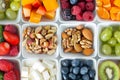 A variety of healthy snacks including fruits, nuts and cheese arranged in small white bowls on a clean background. Ai Royalty Free Stock Photo