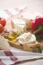 Variety of home made cheese and paprica and herbs, olive oil, olives and bread on a wooden board. Royalty Free Stock Photo