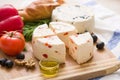 Variety of home made cheese and paprica and herbs, olive oil, olives and bread on a wooden board Royalty Free Stock Photo