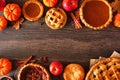 Variety of homemade autumn pies. Pumpkin, apple and pecan. Above view double border over a wood background.