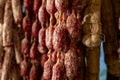 Variety of homemade dried salami sausages hanging in butchery shop in Parma, emilia Romagna, Italy