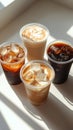 Variety of iced coffee drinks displayed on a bright surface with interesting shadows Royalty Free Stock Photo
