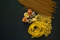 Variety of italian uncooked pasta flat lay on a black background