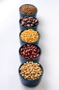 A variety of legumes. Lentils, chickpeas, peas and beans in blue bowls on a white background. Close-up Royalty Free Stock Photo