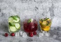 Variety of lemonade on a gray background. Lemonade with raspberries, peach, fresh thyme and refreshing water with lime, cucumber