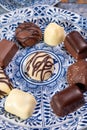 Variety of luxury belgian chocolate pralines bonbons on blue china porcelain plate, tea time Royalty Free Stock Photo