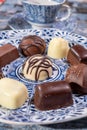 Variety of luxury belgian chocolate pralines bonbons on blue china porcelain plate, tea time Royalty Free Stock Photo