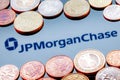 Variety of metal coins on background of JPMorgan Chase bank logo