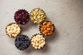 Variety of nuts and raisins in small bowls on grey background Royalty Free Stock Photo