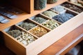 variety of organic tea leaves displayed in wooden compartments