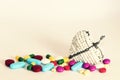 A variety of pills, tablets and capsules, strewn around a white beaded wire heart. Set against a creamy background. Royalty Free Stock Photo