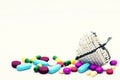 A variety of pills, tablets and capsules, strewn around a white beaded wire heart. Set against a near-white background. Royalty Free Stock Photo