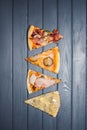 A variety of pizzas lie on a wooden table. view from above.