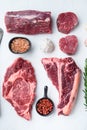 Variety of raw beef meat steaks for grilling with seasoning and utensils, tomahawk, t bone, club steak, rib eye and tenderloin Royalty Free Stock Photo