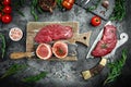 Variety of raw black angus prime meat steaks beef rump steak, Tenderloin fillet mignon for grilling on old meat cleaver on dark Royalty Free Stock Photo