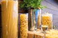 Variety of raw dry pasta penne,fusilli,linguine and spaghetti,shapes of Italian pasta in glass jars on a wooden table,set of many Royalty Free Stock Photo