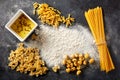 Variety of raw pasta with flour and olive oil on black background Royalty Free Stock Photo