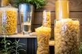 Variety of raw pasta penne,fusilli,macaroni,spaghetti,shapes of pasta in glass jars on a wooden table,Pasta pieces in the form of Royalty Free Stock Photo