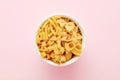 Variety of raw pasta in a white bowl on pink background Royalty Free Stock Photo