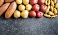 Variety of raw uncooked organic potatoes: red, white, sweet and fingers potatoes over dark texture background. Royalty Free Stock Photo