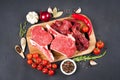 Variety of red meat - raw ribeye beef steaks and chopped raw beef or lamb meat ready for grilling with seasoning Royalty Free Stock Photo