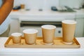 4 variety of sizes of disposable coffee cups made of cardboard and foam on a wooden tray as a display. Takeaway concept. Eco- Royalty Free Stock Photo