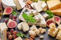 Variety of sliced cheeses with fruits, mint, nuts and cheese cutting knives Royalty Free Stock Photo