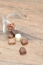 A variety of small chocolates spilling out of a martini glass