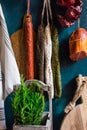 Variety of Spanish cured meat products, charcuterie, fresh rosemary, wood cutting board, hanging on hooks