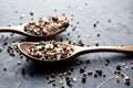 Variety of spices in wooden spoons. Sea salt, mixed pepper, cardamon and mustard seeds on dark black slate background Royalty Free Stock Photo