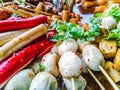 Variety of streamed sausages and meatballs dipped in hot and spicy chilli sauce