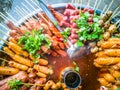 Variety of streamed sausages and meatballs dipped in hot and spicy chilli sauce