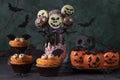 Variety of treat for Halloween - bright cakes in shape of bats, pumpkin-shaped mousse cakes, cake pops skeletons and Royalty Free Stock Photo