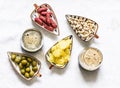 Variety of tapas snacks and dark beer on a light background, top view. Sausages, potato chips, nuts, olives and beer Royalty Free Stock Photo