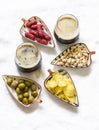 Variety of tapas snacks and dark beer on a light background, top view. Sausages, potato chips, nuts, olives and beer Royalty Free Stock Photo