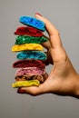 Variety of tasty multicolored blanks of macaron broken in half in female hands