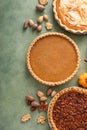 Variety of traditional Thanksgiving pies on green background with copy space