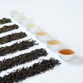 Variety types of tea in little cups and natural tea leaves