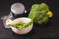 Variety of vegetables section of broccoli , bunch of green beans and three cloves of garlic with metal strainer Royalty Free Stock Photo