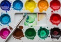 With a variety of vibrant paints in circular pans arranged in a Royalty Free Stock Photo